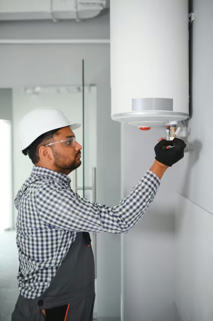 indian-male-plumber-adjusting-boiler-bathroom