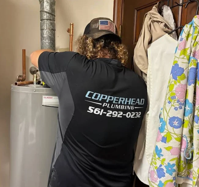 Technician performing water heater replacement