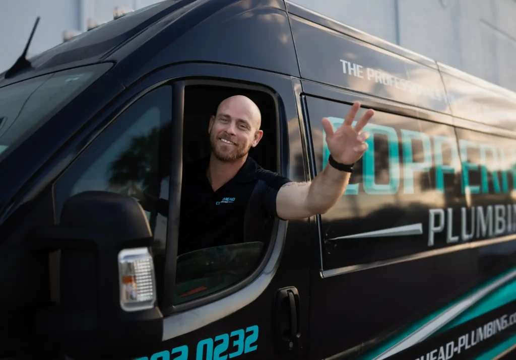 Friendly plumber from Copperhead Plumbing waving from company service van