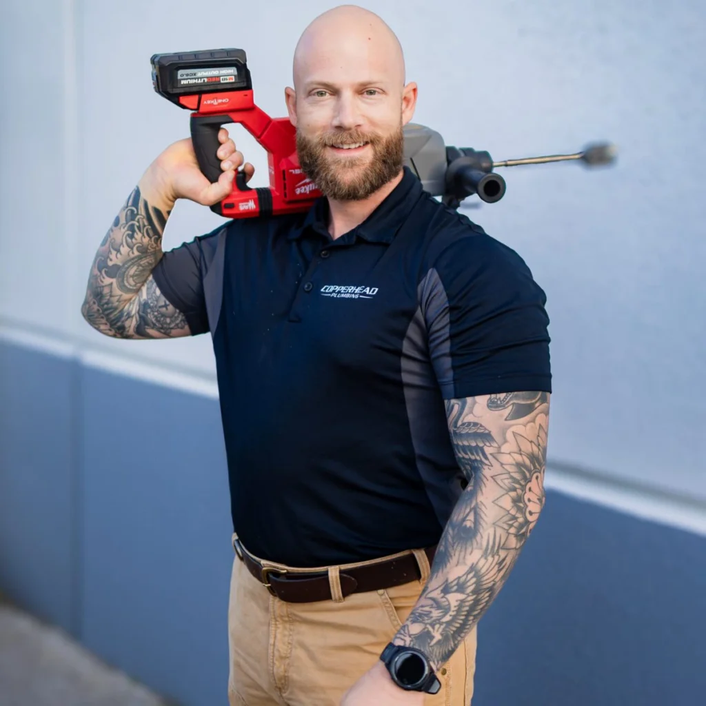 copperhead plumbing technicial holding a drain cleaning tool